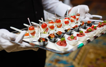 A waiter is serving sweet desserts and appetizers for high-end catering